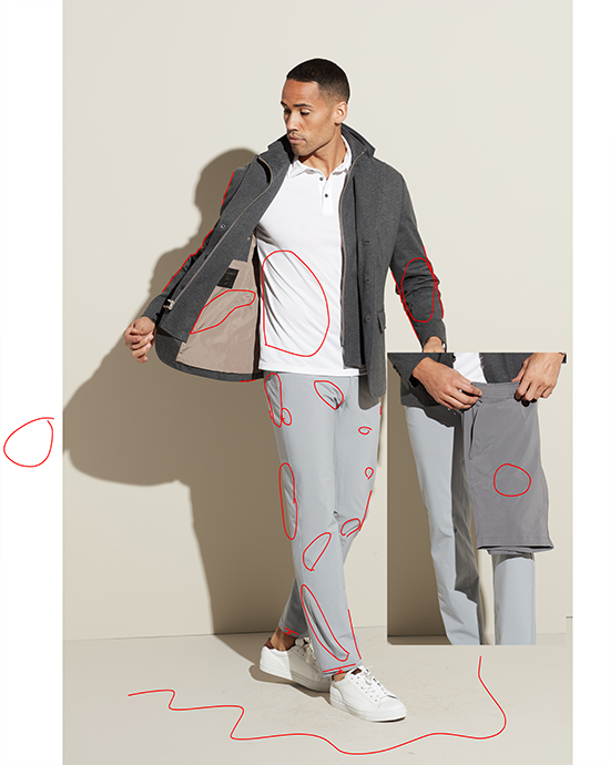 Man revealing inside of gray jacket, wearing white polo and gray trousers, with red scribbles on image.