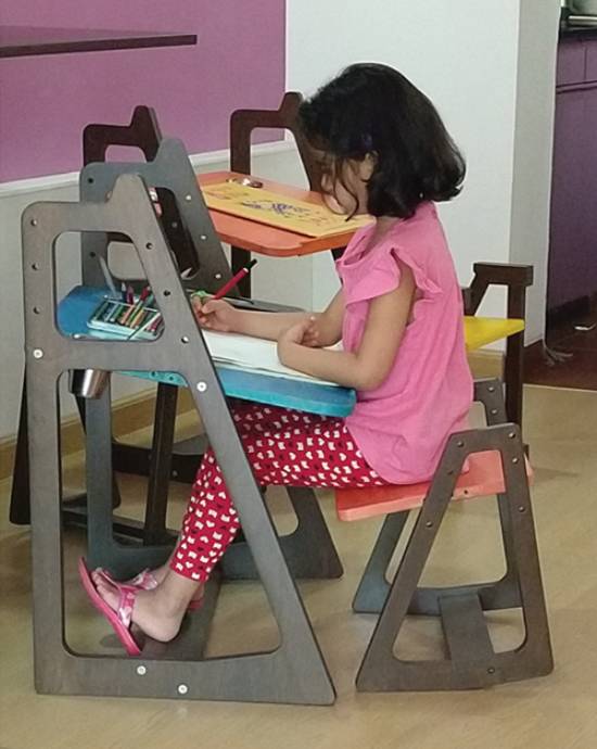 Vector conversion services for a young girl drawing at a wooden learning tower with focus.