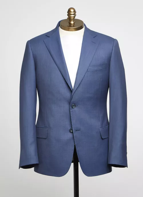 Tailored blue blazer on mannequin with notched lapel, two buttons, and front pockets.