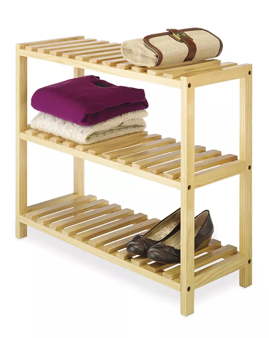 A wooden shoe rack holding shoes and stacked towels on a white background, showcasing our image recoloring services.