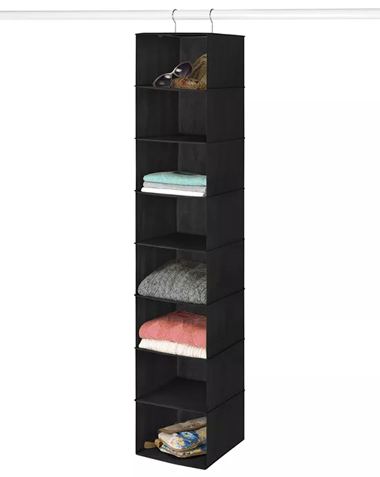 A tall, black, hanging fabric closet organizer with six shelves containing towels and a pillow.
