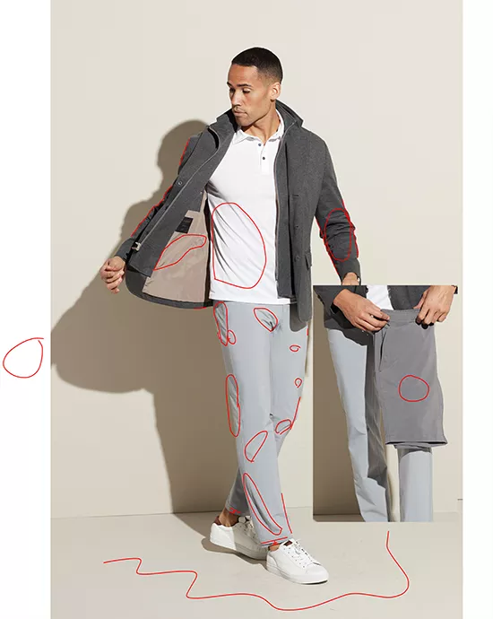 Man revealing inside of gray jacket, wearing white polo and gray trousers, with red scribbles on image.