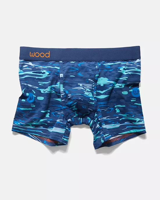 Blue camo-print men's boxer briefs with navy waistband and orange "wood" brand logo.