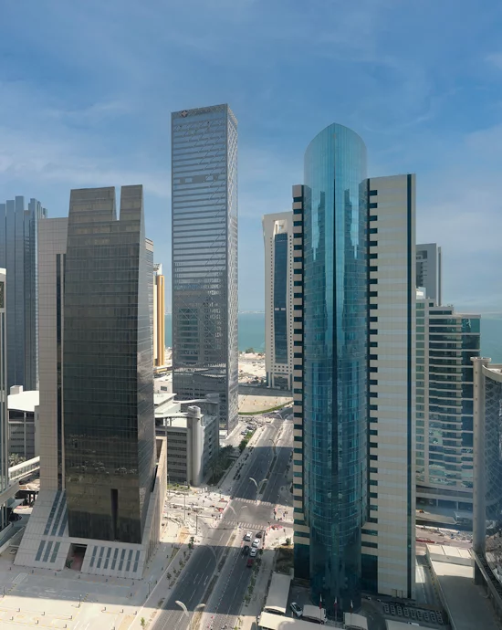 Aerial view of modern cityscape with skyscrapers and clear blue skies.