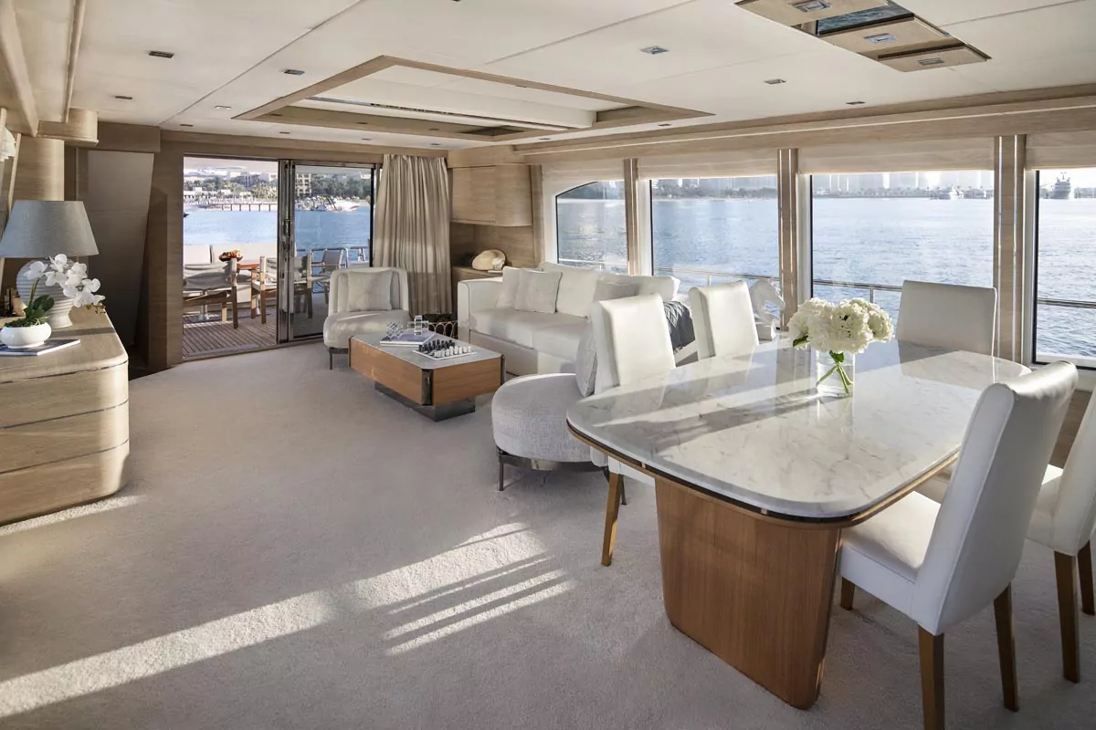 Spacious yacht lounge and dining area with scenic water views, elegant decor for Real Estate Photo Editing Services.